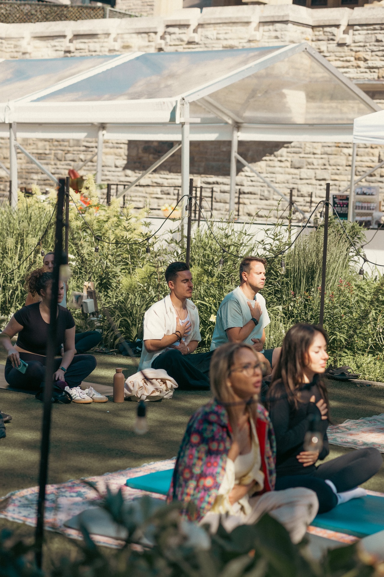 Open-air breathwork beside Casa Loma stone
